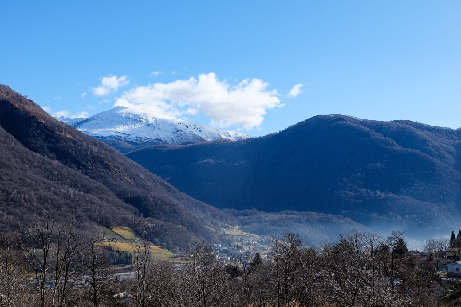 Ici et là, une trouée dans la forêt permet de voir les sommets environnants enneigés.