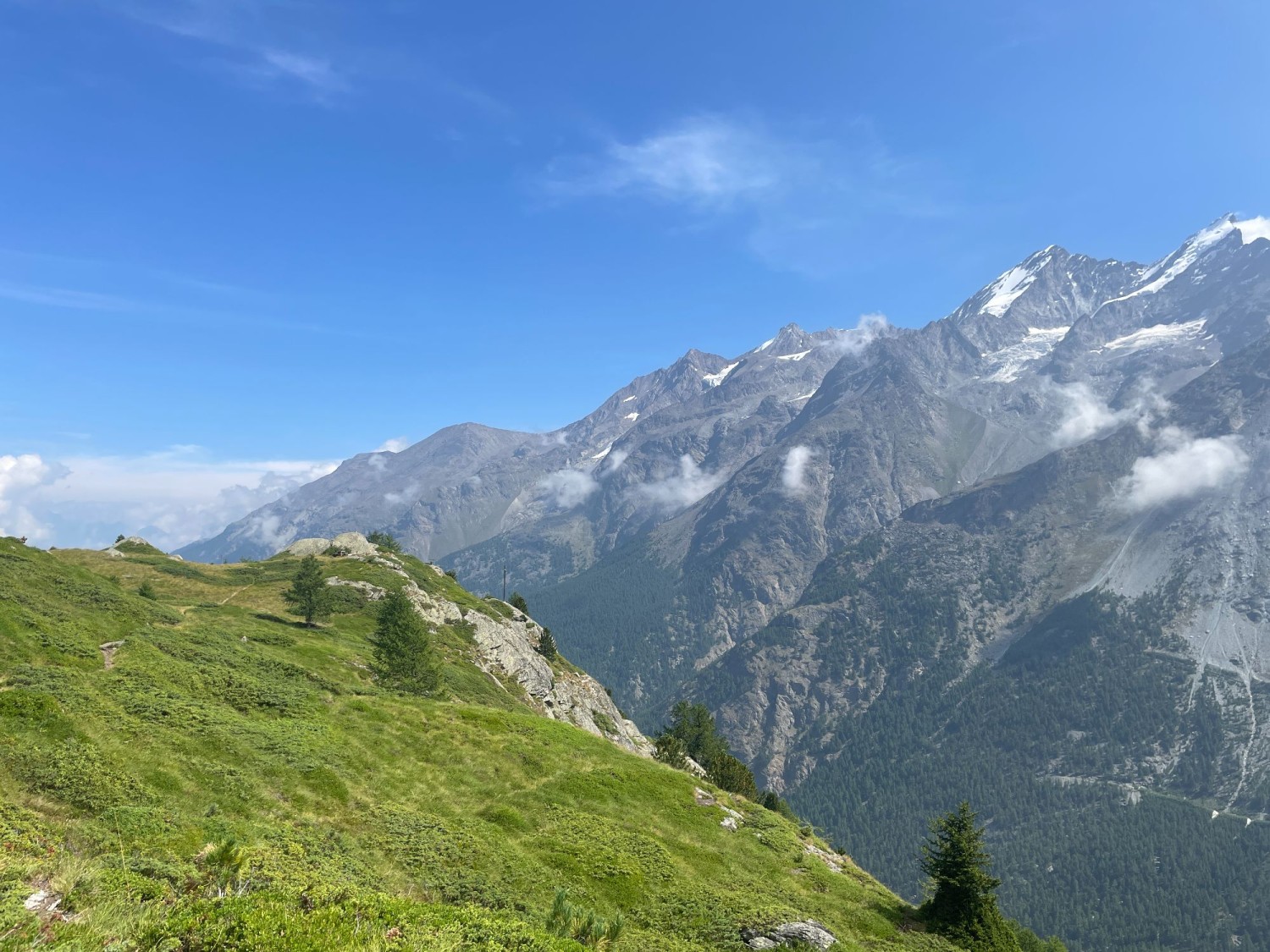 La croix sommitale est en vue. Tout comme l’imposant paysage formé par les montagnes valaisannes, juste en face.