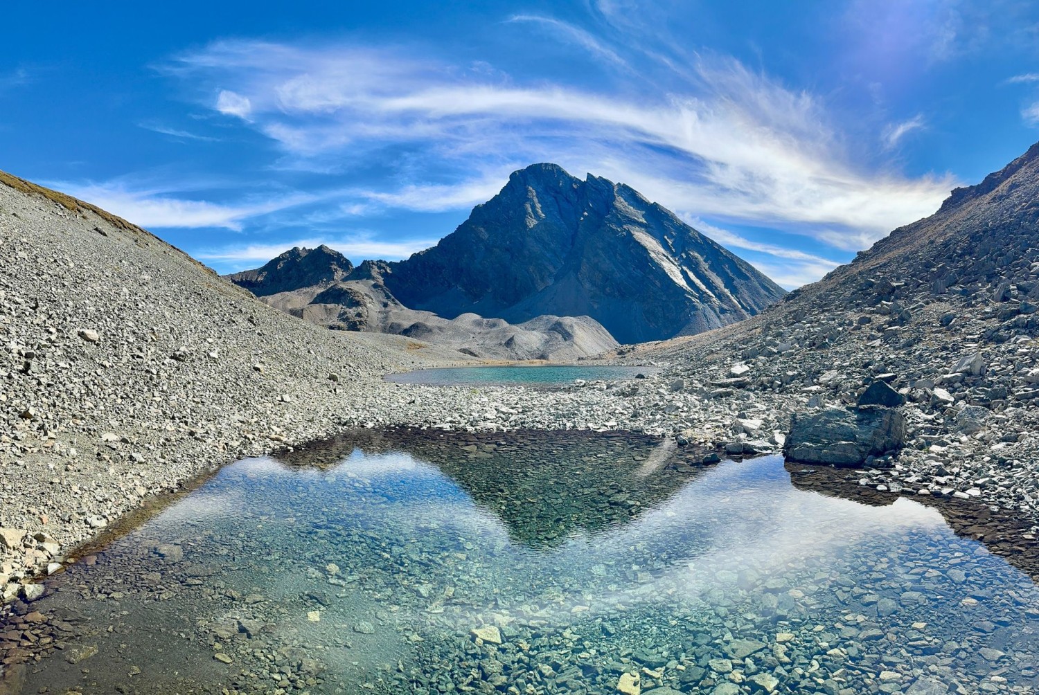 Le Piz Linard se reflète dans un petit lac, sur le col de la Vereina.